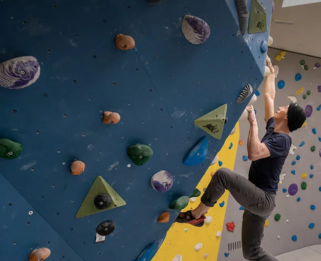 Mann beim Klettern in Kletterhalle