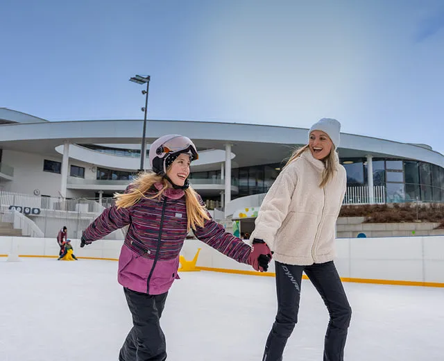 Mama und Tochter beim Eislaufen