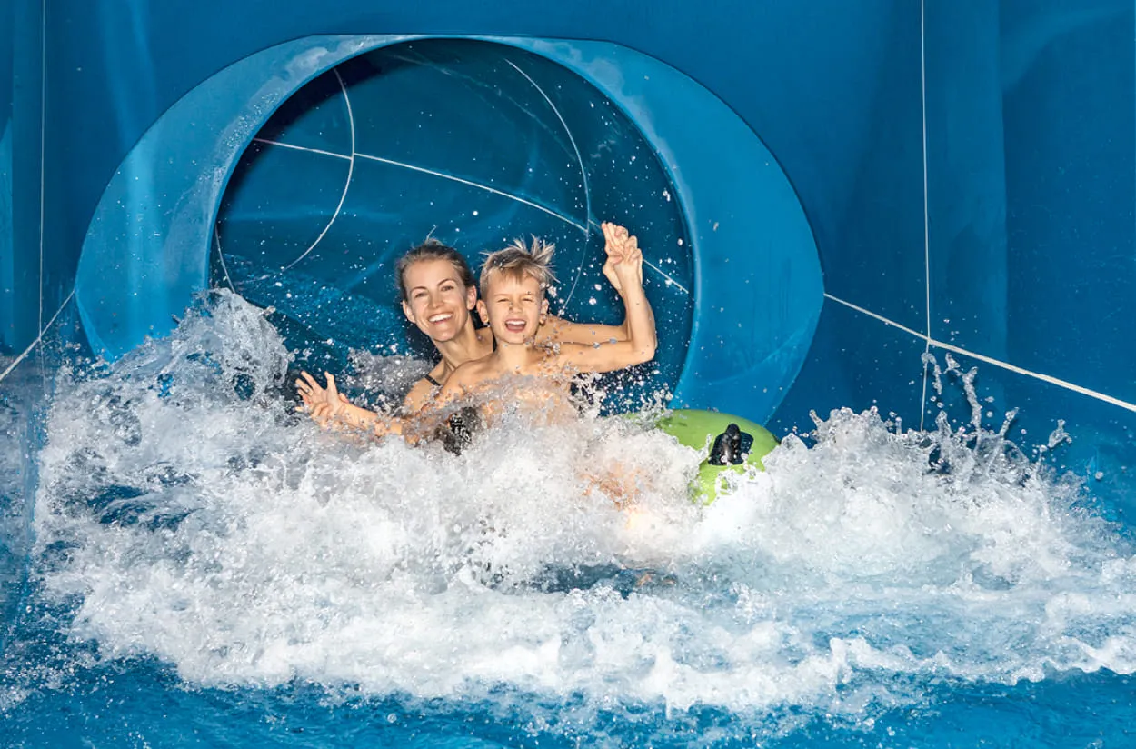 Mama mit Kind auf der Wasserrutsche